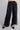 Black wide-leg pants with an elastic waistband and lace panel detailing along the lower legs. The pants feature functional side pockets and a relaxed, flowing silhouette.