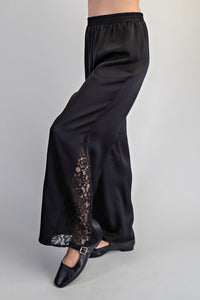Black wide-leg pants with an elasticized waist and lace panel inserts along the side seams, worn with black dress shoes.