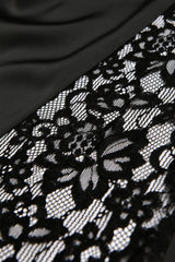 Black lace trim with an intricate floral pattern featuring open mesh details, displayed against a dark fabric background. The delicate lace showcases fine embroidered designs with a romantic, elegant aesthetic suitable for lingerie or apparel embellishment.