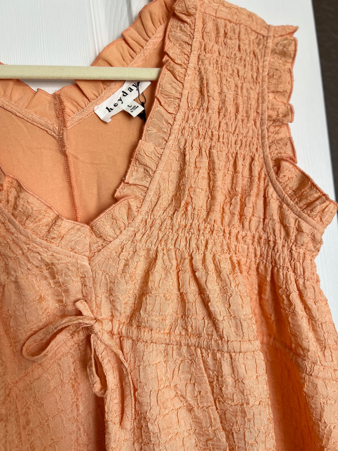 Light brown textured dress with a brand tag on a white background