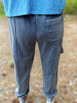 Person wearing blue jeans and a blue shirt with a blurred natural background