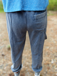 Person wearing blue jeans and a blue shirt with a blurred natural background