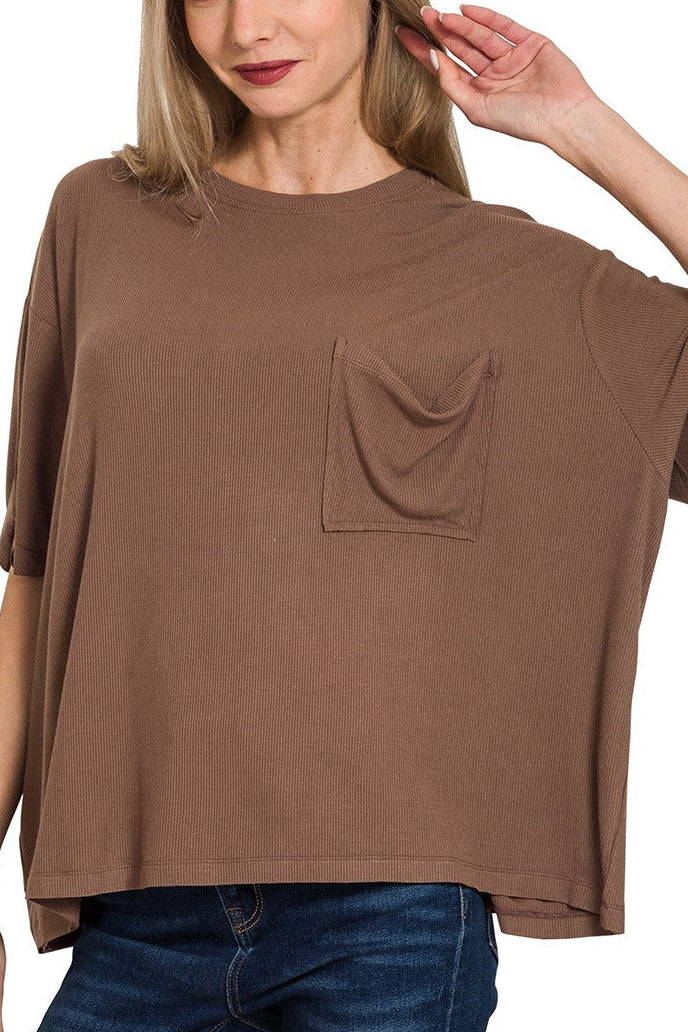 Woman wearing a brown oversized t-shirt with a pocket on a white background