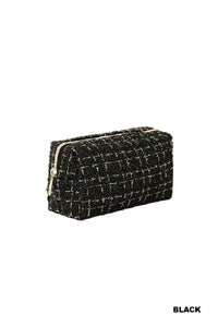 A black quilted cosmetic bag with a textured tweed pattern and gold-tone zip closure, displayed against a white background.