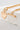 Gold-toned chain bracelet with a polished heart charm and toggle clasp, displayed on a white marble stone surface.