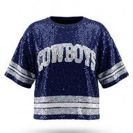 A navy blue sequined short-sleeve sweatshirt featuring "COWBOYS" in white and silver lettered appliqué across the chest, with matching silver sequined stripes on the sleeves and hem.