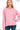 A woman wearing a candy pink soft melange long-sleeve crew neck top paired with dark blue jeans, showcasing the relaxed fit and comfortable texture of the garment.