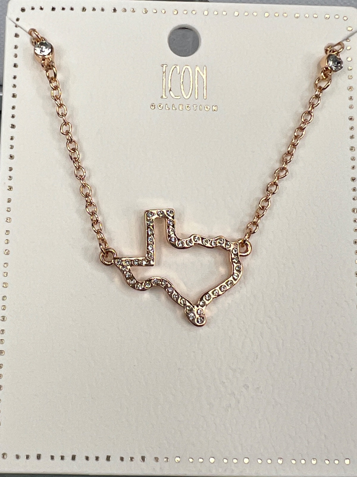 Rose gold-toned necklace from Icon Collector featuring a geometric pendant with crystal embellishments connected to a delicate chain. The pendant displays an angular, abstract design with sparkly rhinestone detailing throughout.