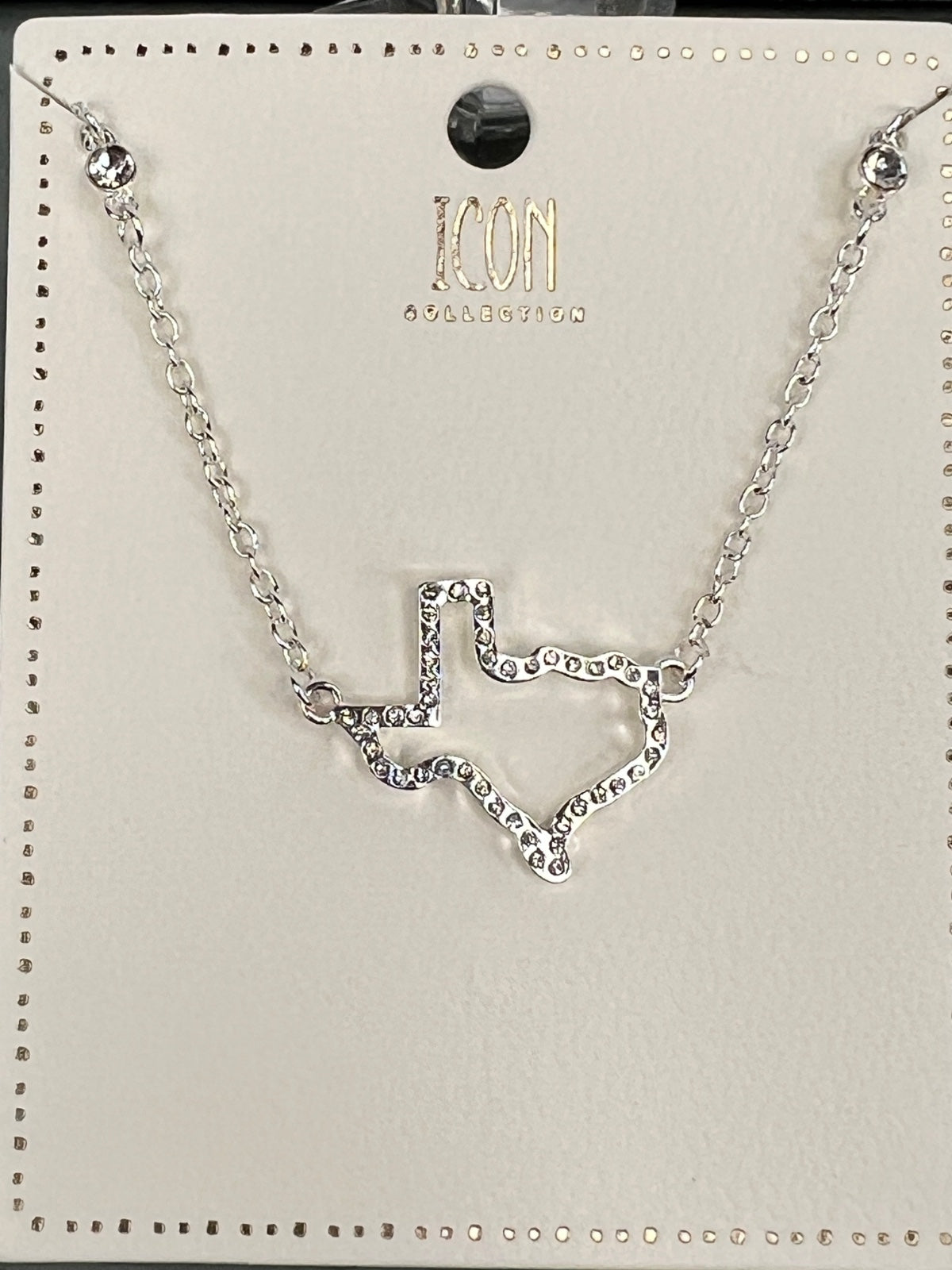 Silver-tone chain necklace from ICON Collection featuring a rhinestone-embellished chevron pendant in the center, displayed on a branded product card with a black circular ornament at the top.