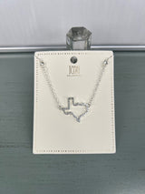 A silver-toned delicate chain necklace featuring a geometric V-shaped pendant with crystal embellishments, displayed on an ivory ICON branded jewelry card with decorative beading around the edges.