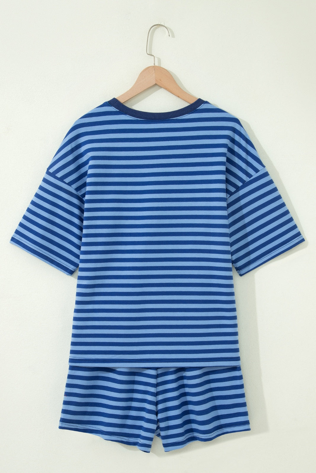 A blue and light blue striped short-sleeve t-shirt and matching shorts set displayed on a wooden hanger against a white background. The coordinating two-piece outfit features horizontal stripes throughout and a relaxed, casual fit.