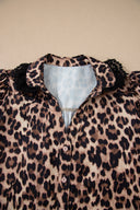 Leopard print blouse with puffed black ruffled sleeves and a light blue collar, featuring white button closures down the front.