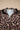 Leopard print blouse with puffed black ruffled sleeves and a light blue collar, featuring white button closures down the front.