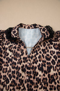 Leopard print blouse with puffed black ruffled sleeves and a light blue collar, featuring white button closures down the front.