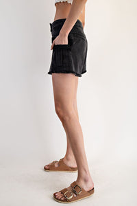 Black denim shorts with a distressed, frayed hem and front pockets, styled with brown buckled slide sandals on a neutral background.