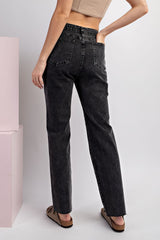 Woman wearing high-waisted black straight-leg jeans with a cropped tan top and cork sandals, shown from behind to display the classic five-pocket denim styling and relaxed fit.