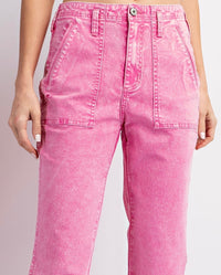Pink acid-wash denim pants with a high waist, front patch pockets, and a straight-leg silhouette. The jeans feature decorative topstitching and a silver button closure.