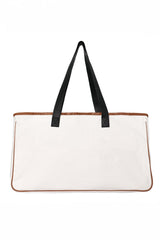 A large cream and tan tote bag with brown leather trim along the top and bottom edges, featuring two black fabric handles for carrying.