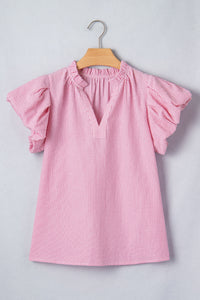 A pink ribbed short-sleeve dress for children hanging on a wooden hanger, featuring ruffled flutter sleeves and a simple crew neckline.