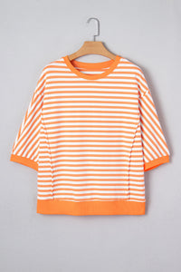 A bright orange and white striped short-sleeve sweatshirt displayed on a wooden hanger against a gray background. The garment features horizontal stripes throughout, ribbed cuffs and hem, and a classic crew neckline.