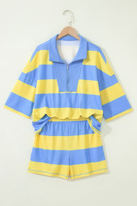A blue and yellow striped rugby-style short-sleeve shirt with matching shorts displayed on a wooden hanger against a white background. The set features bold horizontal stripes, a collared neckline with a quarter-zip closure, and an elastic waistband on the shorts.