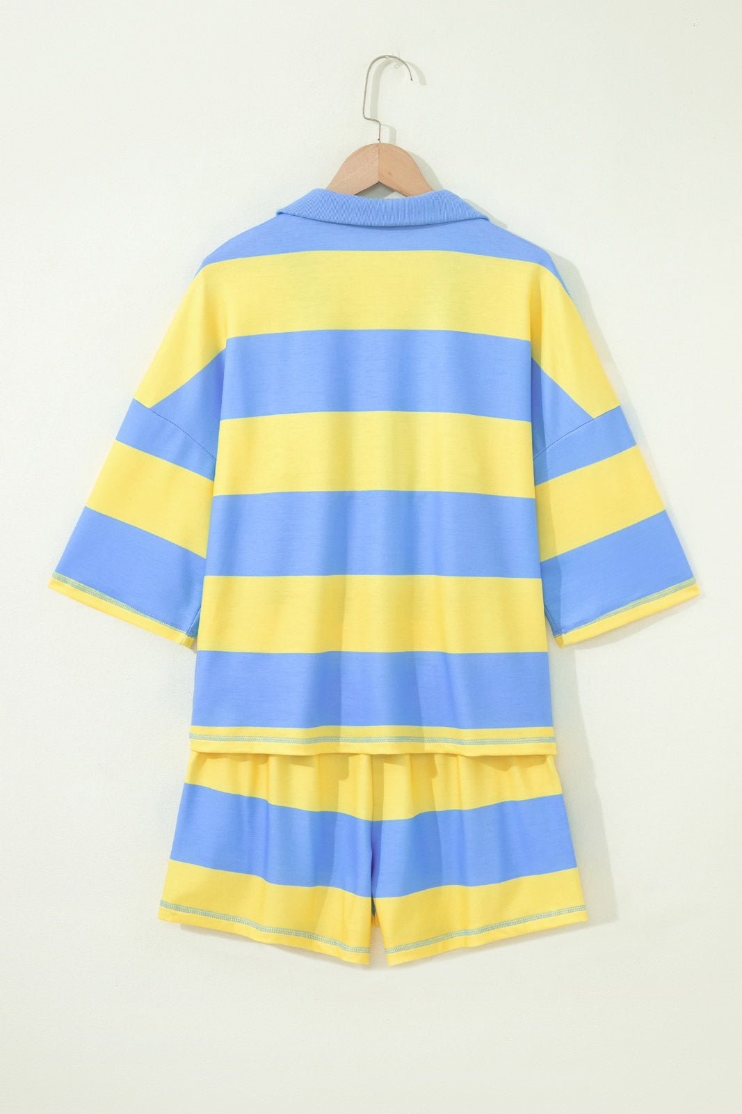 A children's two-piece set featuring a short-sleeved striped shirt and matching shorts in alternating blue and yellow horizontal stripes, displayed on a wooden hanger against a white background.