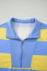A colorblock striped sweater with horizontal blue and yellow stripes, featuring a blue ribbed collar and full-length zip front closure.