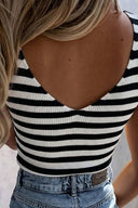 A sleeveless striped crop top featuring black and white horizontal stripes with a open back design, paired with light blue denim jeans.