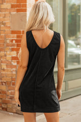 A sleeveless black ribbed knit dress hanging on a wooden hanger against a white background. The dress features a simple A-line silhouette with a round neckline and a vertical center seam detail.
