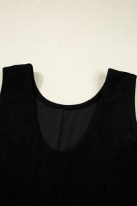 Black ribbed sleeveless tank top displayed flat against a cream background, showing the round neckline and textured knit fabric detail.