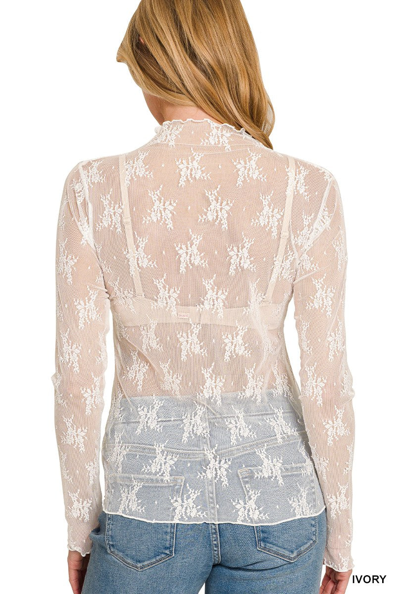 Rear view of an ivory lace long-sleeve crop top featuring an all-over white floral embroidered pattern on sheer mesh fabric, worn over a light blue denim.