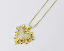 Gold-toned heart pendant necklace featuring cubic zirconia crystals covering the center with decorative gold ball accents around the border, suspended from a matching box chain.