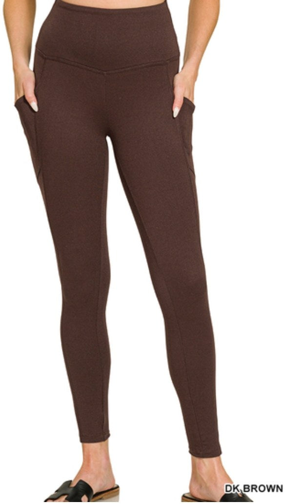 Dark brown high-waisted leggings with functional side pockets and a fitted silhouette that extends to the ankles.