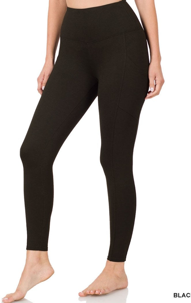 Black high-waisted leggings with a full-length fit and side pocket detail, shown on a model from waist to bare feet against a white background.