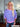 Woman wearing a blue and pink striped three-quarter sleeve pullover sweater with pink ribbed trim at the neckline and cuffs, paired with blue jeans.