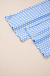 A light blue and white striped fabric laid flat on a neutral background, showing vertical pinstripes and folded edges with visible stitching detail.