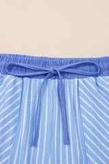 Close-up of blue striped swim shorts with a solid blue drawstring waistband tied in a bow knot. The fabric features vertical white and blue stripes throughout.