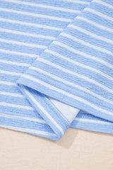 A light blue and white striped towel folded to show its soft, textured surface and finished edge against a neutral background.