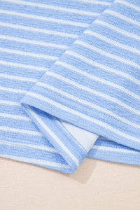 A light blue and white striped towel folded to show its soft, textured surface and finished edge against a neutral background.
