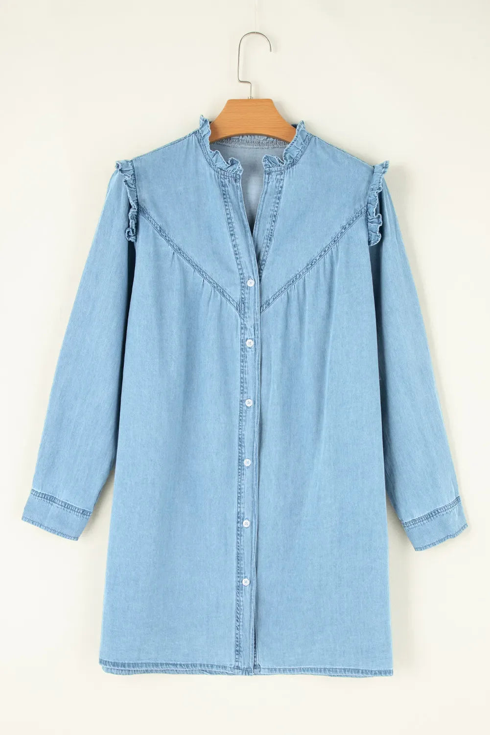 Light blue denim dress on a hanger against a white background
