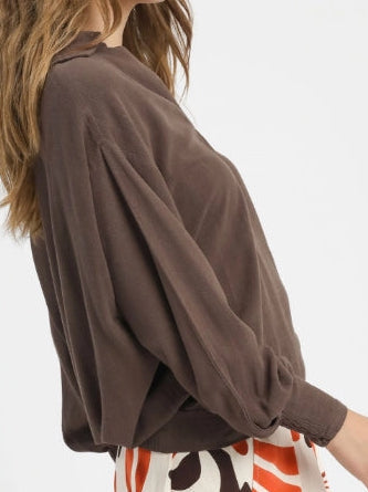 Woman wearing a brown oversized sweater on a white background