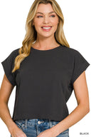 A woman wearing a black short-sleeved crew neck t-shirt with rolled cuffs, paired with blue denim jeans. The shirt has a relaxed, casual fit.
