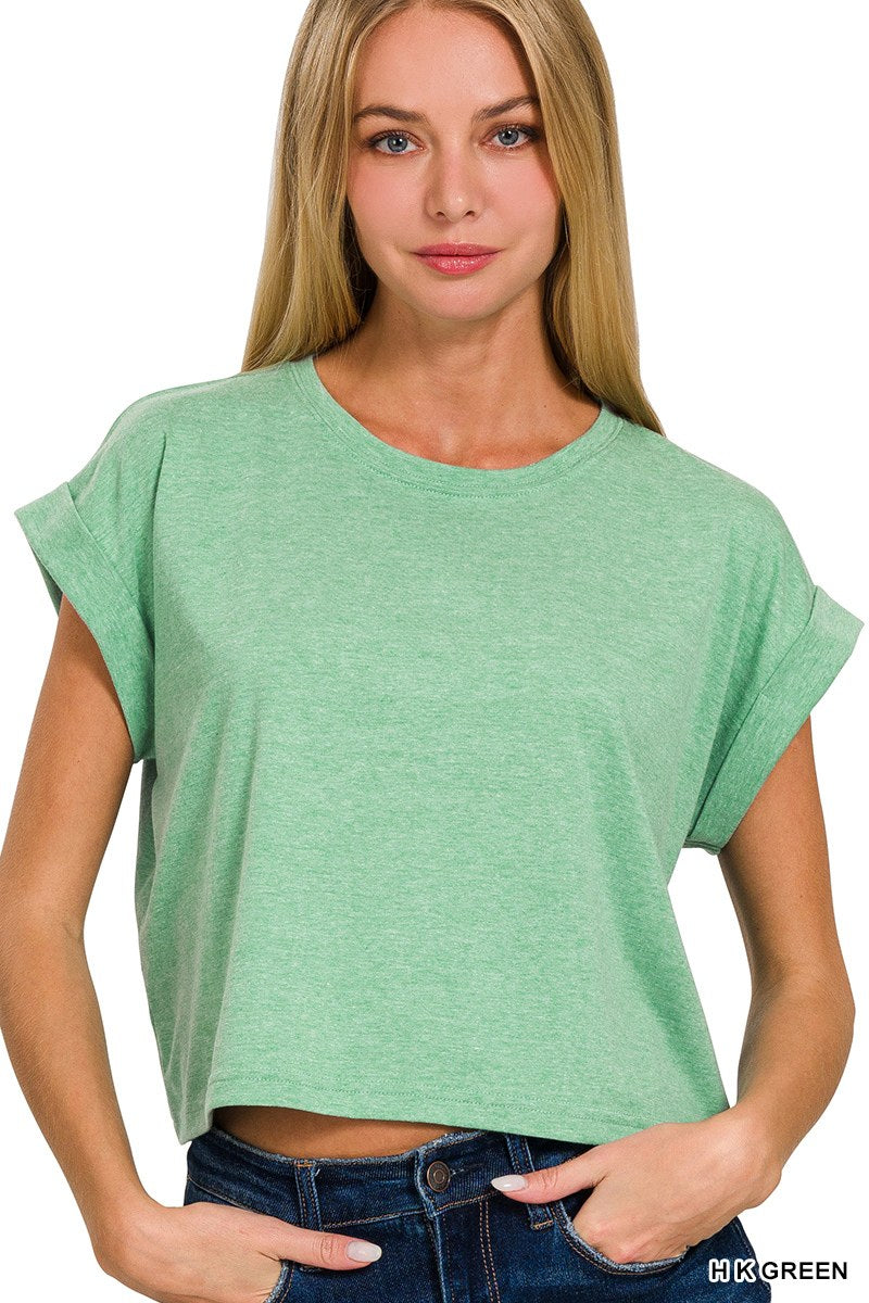 A woman wearing a mint green heathered crop t-shirt with short rolled sleeves and a crew neckline, paired with dark blue jeans.